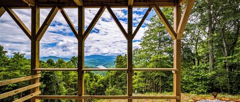 Un pabellón de madera con vistas a un paisaje montañoso.