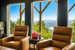 A room with two leather chairs facing a large window overlooking a mountainous landscape. - Timber Ridge Reserve-new 4 bed/4 ba home- stunning Smoky Mountain & lake views (Bryson City)