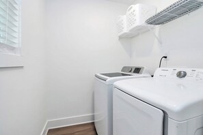 A laundry area with a Samsung washing machine and dryer, a drying rack, and a window with blinds. - The Modern Getaway, 3BR, Workspace + Downtown Kannapolis (Kannapolis)