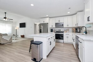 A modern kitchen with white cabinets, stainless steel appliances, and a central island. - The Modern Getaway, 3BR, Workspace + Downtown Kannapolis (Kannapolis)
