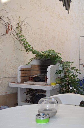 Eine Küchenzeile mit Backofen, einer weißen Arbeitsplatte und einem Blumentopf.