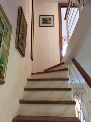 A staircase with wooden steps and a handrail, leading to a landing with a framed picture. - Sea View Paradise Retreat in Nikiti (Nikiti)