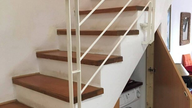 Un escalier avec des marches en bois et des rampes blanches.