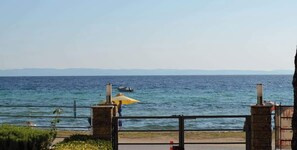 Weitläufige Küstenlandschaft mit blauem Himmel, Wasser und einer entfernten Küste.