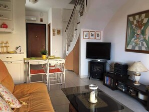 A living room with a sofa, a coffee table, a TV, and a fireplace. - Sea View Paradise Retreat in Nikiti (Nikiti)