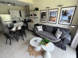 A modern living space with a dining area, a sofa, and a kitchen. - Tropical Bliss apt, Beach, Golf, Dining,Gated community near downtown Punta Cana (Punta Cana)