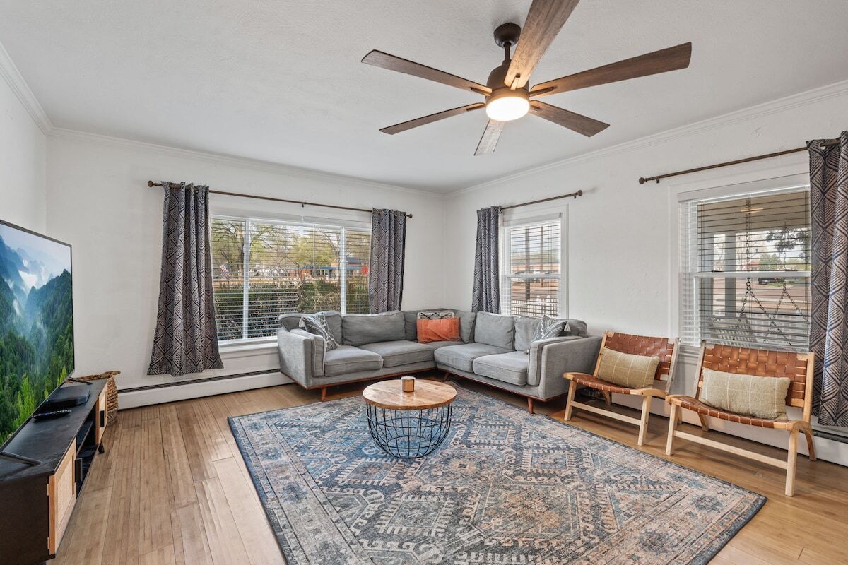 A living room with a sectional sofa, a coffee table, and a ceiling fan.