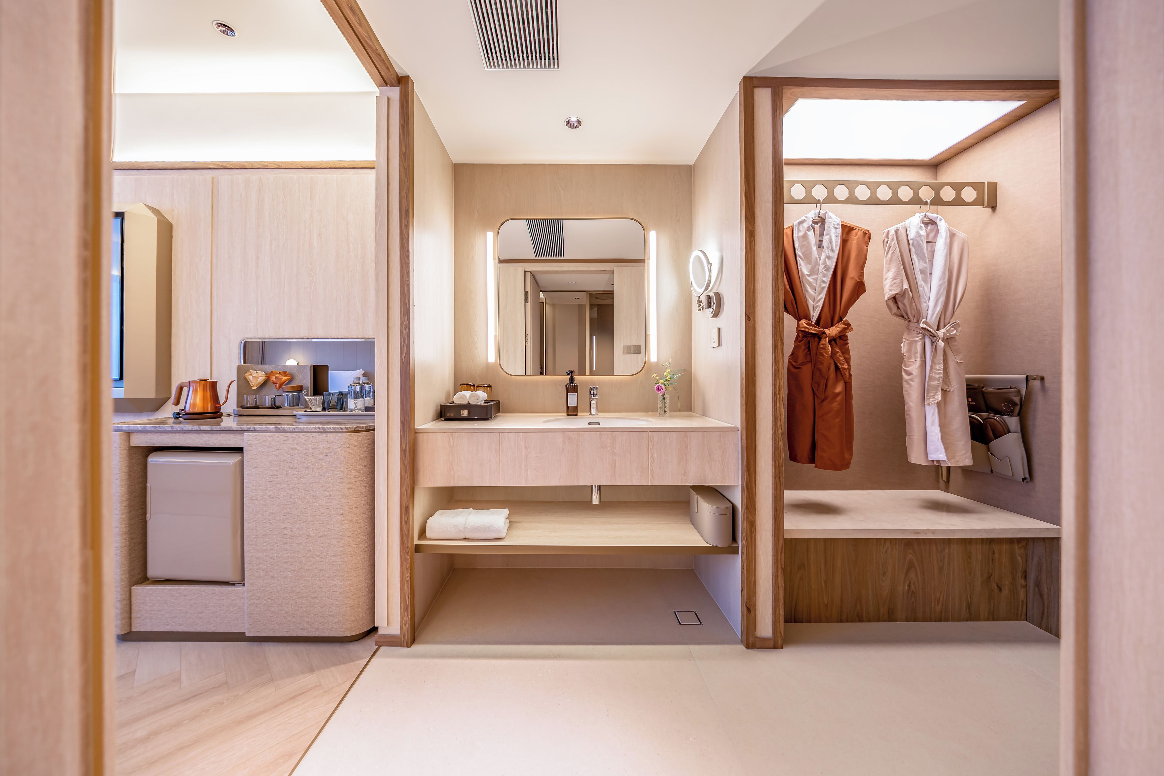 Une salle de bain moderne équipée d’un lavabo, d’un miroir, d’un porte-serviettes et d’un petit meuble de rangement.
