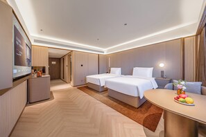 A hotel room with two beds, a desk with a vase of flowers, and a minibar. - Crystal Hotel Guiyang Penshuichi Baoshan (Guiyang)