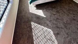 Ein Schlafzimmer mit einem Bett, einem Nachttisch, einer Wand-Klimaanlage, einem Deckenventilator und einem Fenster mit Blick.