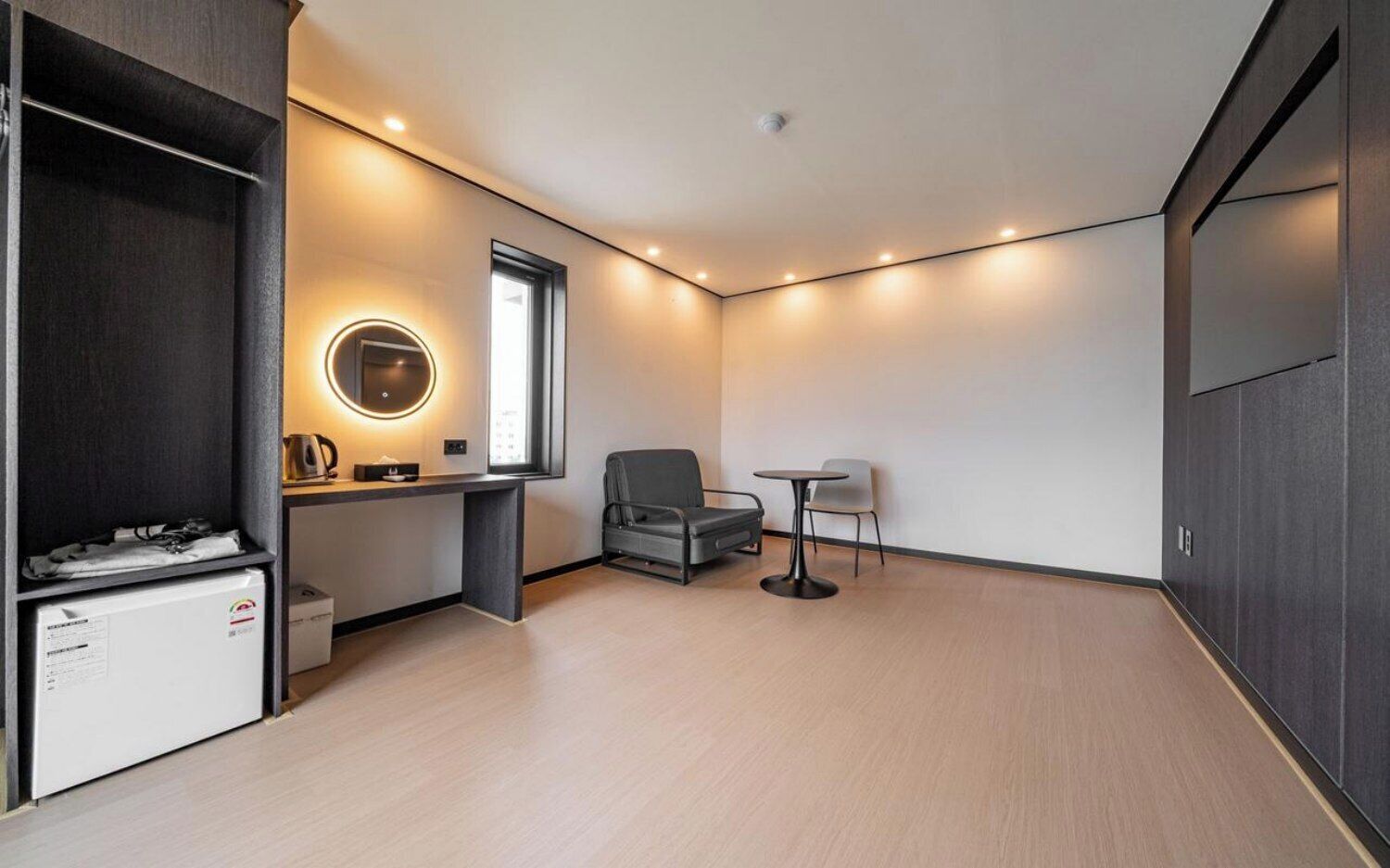 A modern room with a desk, chair, and a small table.