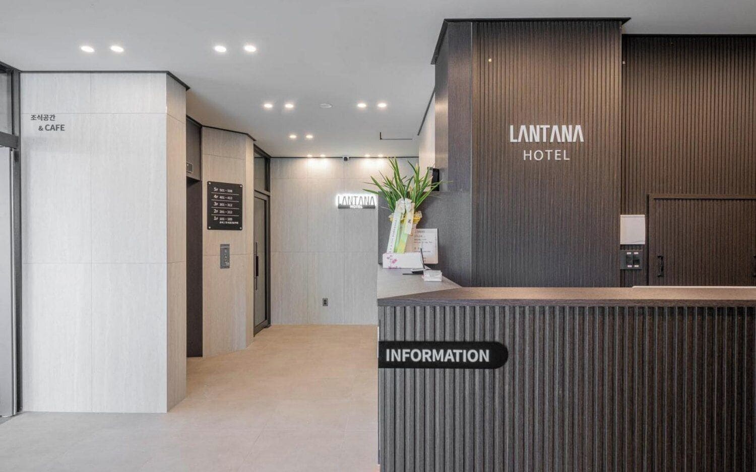 A hotel reception area with a modern design, including a reception desk labeled 'LANTANA HOTEL' and an 'INFORMATION' sign.