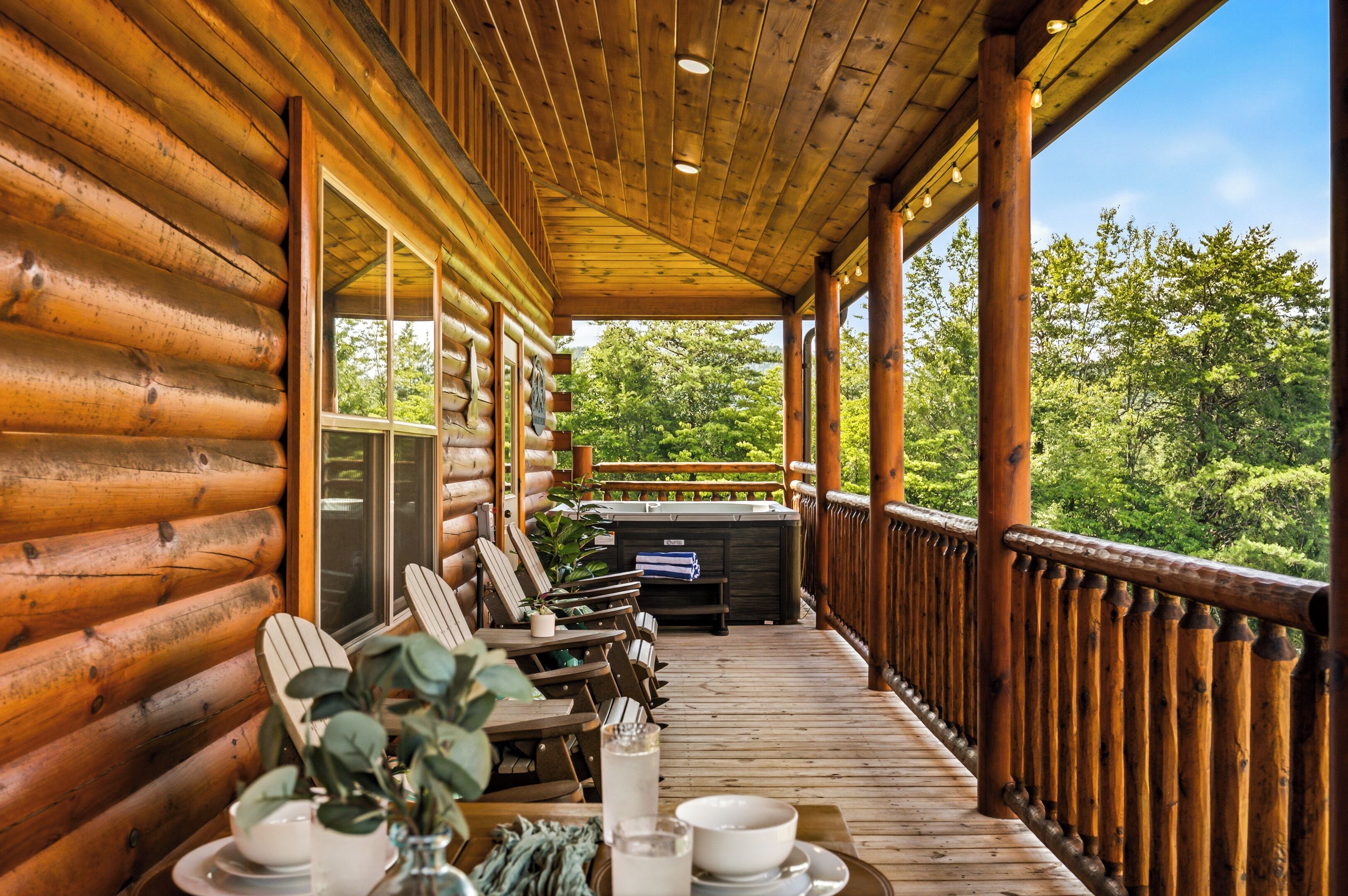 A wooden log cabin with a covered porch, outdoor seating, and a hot tub.