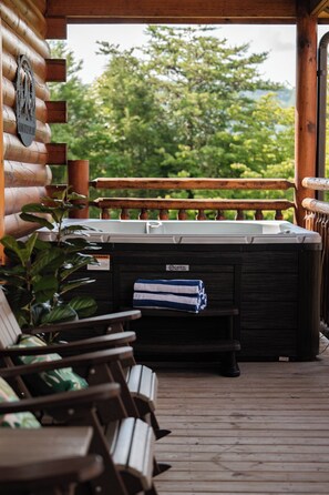 A wooden deck with a hot tub, a wooden bench, and a sign indicating a spa area. - Heated Indoor Pool + Hot Tub + Game Room Near Parkway (Pigeon Forge)