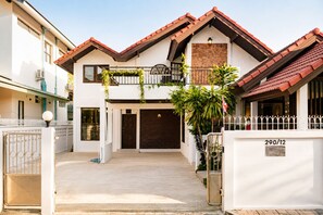 A two-story building with a white facade, a brown door, and a red-tiled roof. - 4-Bedroom House in Chang Khlan Chiang Mai (Chang Wat Chiang Mai)