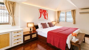 A bedroom with a bed, bedside tables, a desk, and a window with curtains.