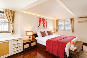 A bedroom with a bed, bedside tables, a desk, and a window with curtains.