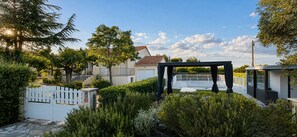 A residential property with a gated entrance, a modern outdoor structure, and a house with a tiled roof. - Large, air-conditioned villa with a private, secure pool and no overlooking neighbors - Servian (Servian)