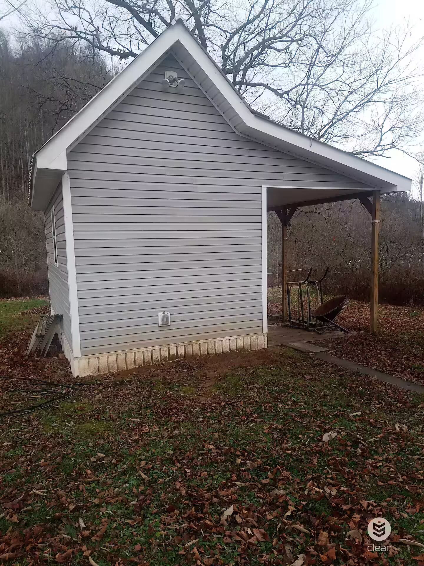 Un piccolo deposito a un piano con tetto spiovente e un portico coperto.