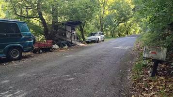 Una strada sterrata con un furgone e un'auto bianca parcheggiati a lato.