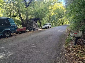 Ein Schotterweg mit einem Van und einem weißen Auto, die am Straßenrand geparkt sind.