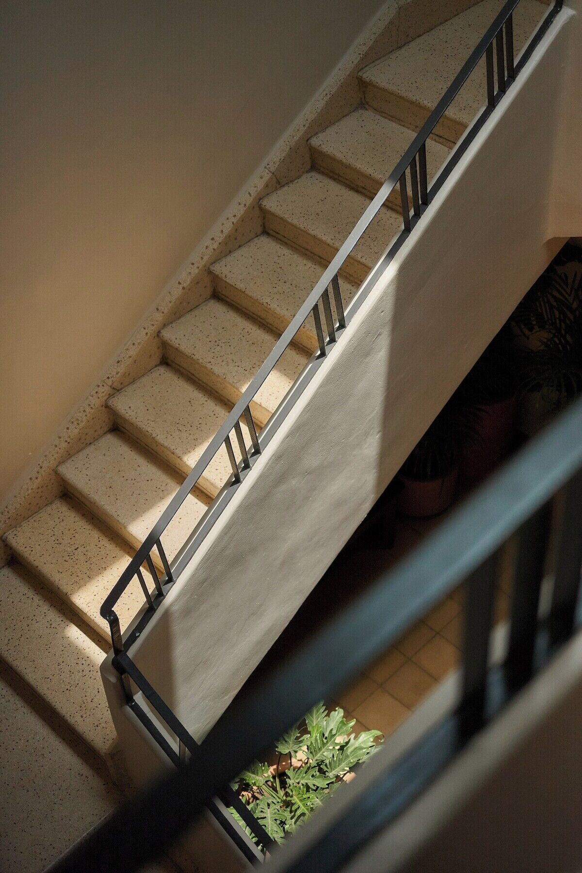Una scala con ringhiera in metallo e gradini color beige.