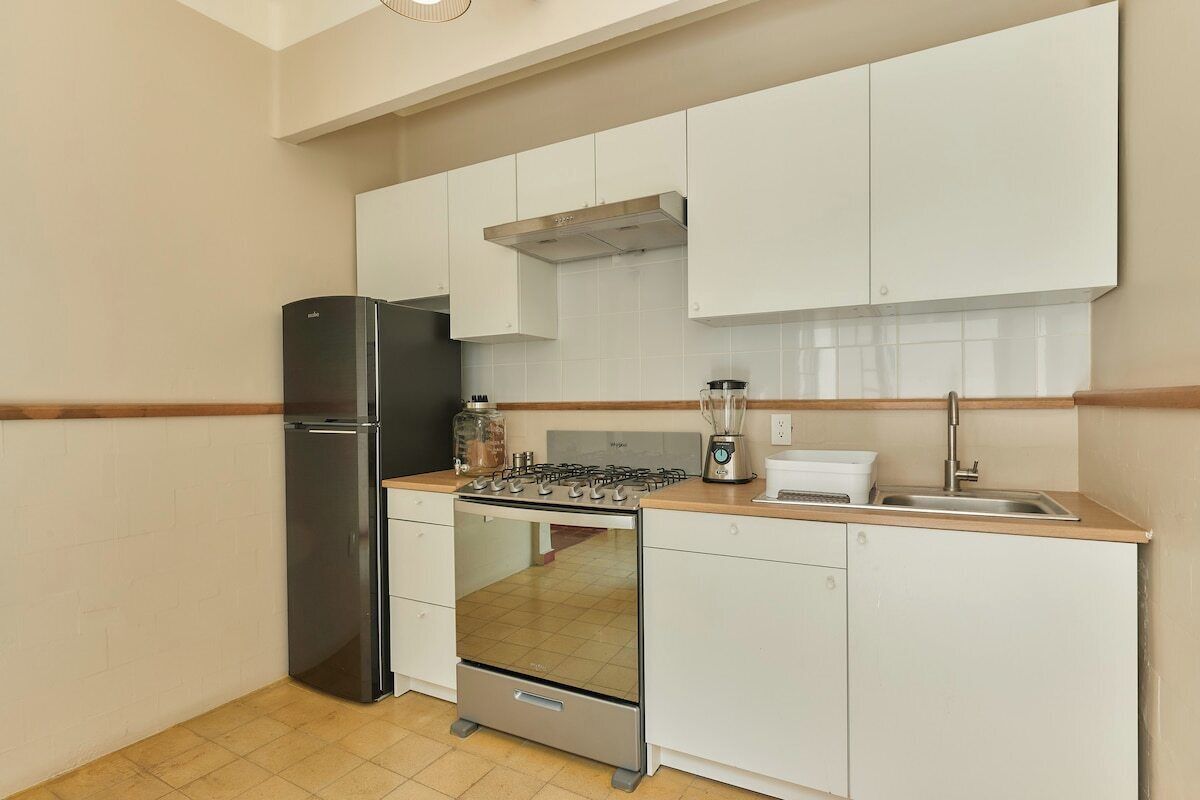 A compact kitchen with a refrigerator, stove, and sink.