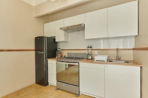 A compact kitchen with a refrigerator, stove, and sink. - Live Oaxaca: Home Near the Historic Center (Oaxaca de Juárez)