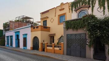 A row of buildings with distinct architectural styles, including a building with a balcony and another with a gate.