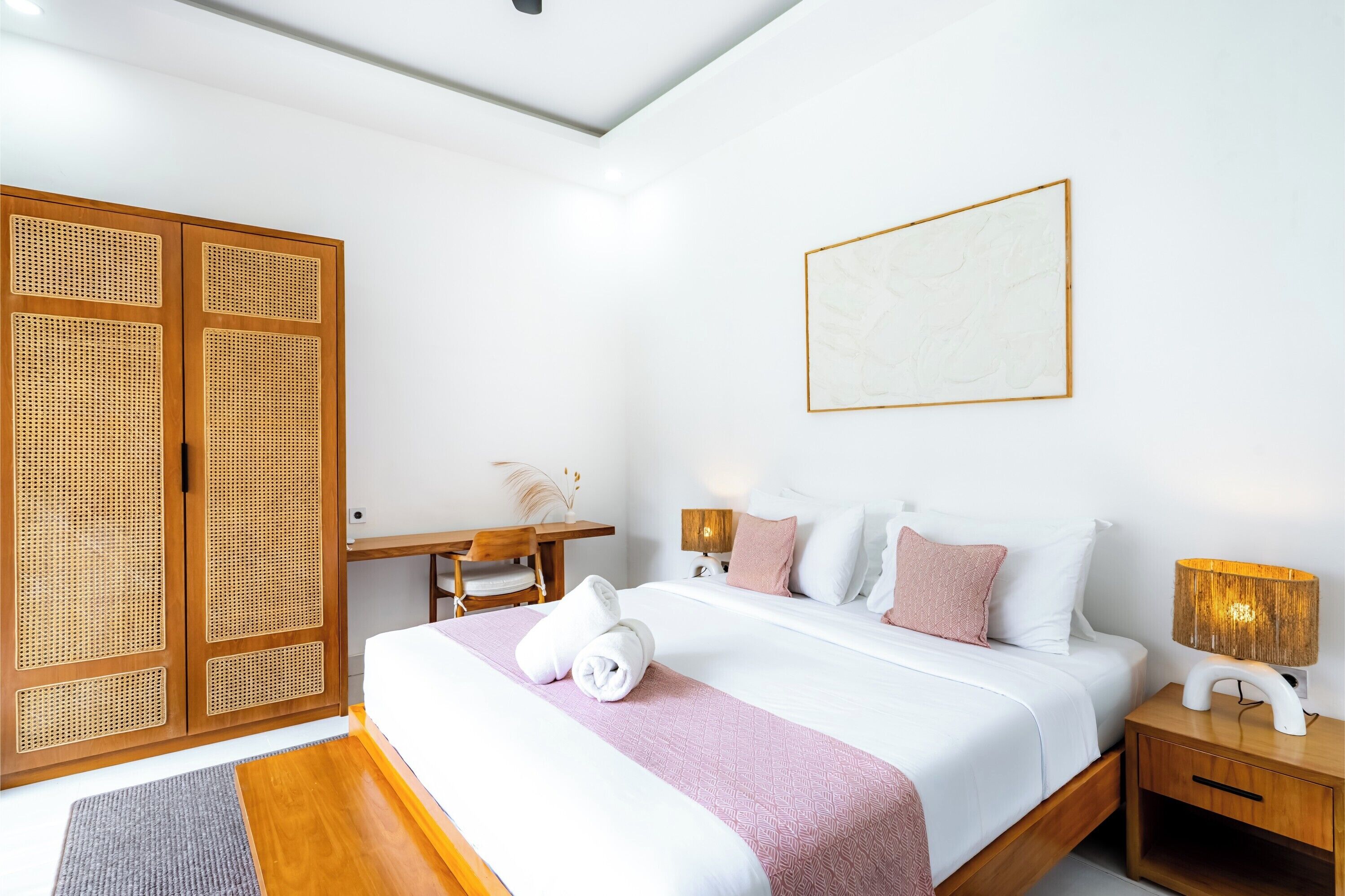 Una habitación de hotel con cama, mesitas de noche, escritorio y armario.