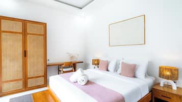 Una habitación de hotel con cama, mesitas de noche, escritorio y armario.