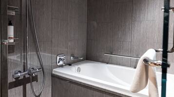 Een moderne badkamer met een inloopdouche, een badkuip en een douchecabine met glazen wanden.