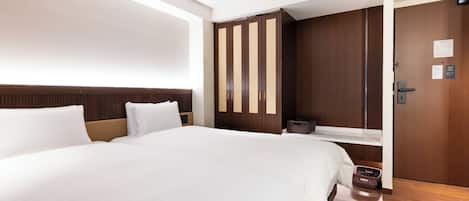 Habitación de hotel con una cama grande, un armario de madera y una puerta con un cartel.