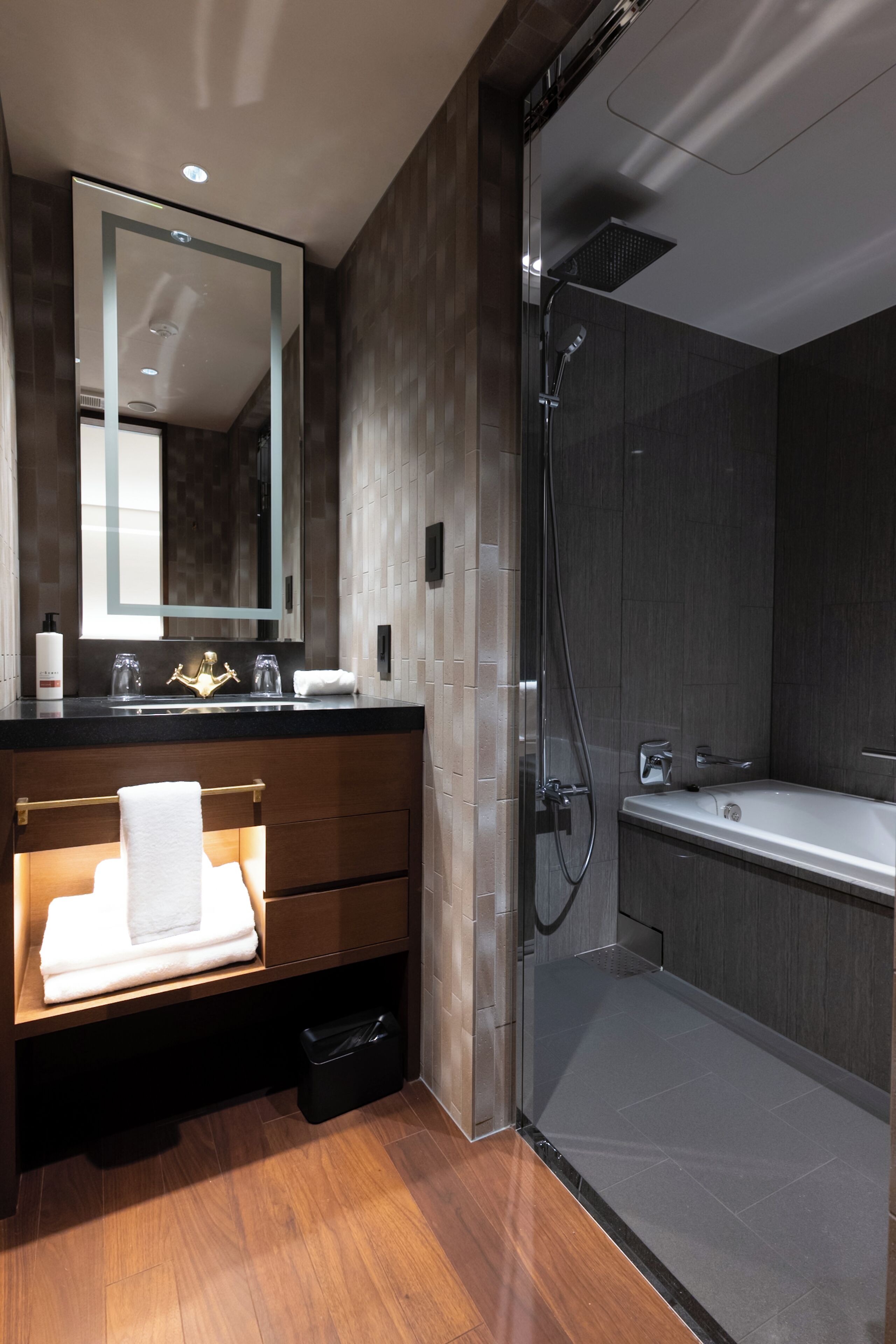 Un baño moderno con cabina de ducha de vidrio, tocador con espejo y bañera.