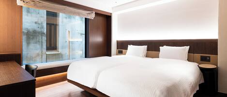 Habitación de hotel moderna con una cama grande, un escritorio y vistas al exterior.