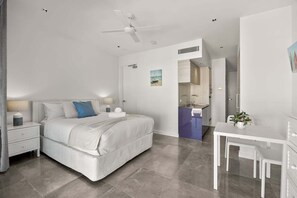 Un dormitorio moderno con cama, mesitas de noche, escritorio y silla.