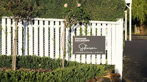 Ein weißer Zaun mit einem Schild, auf dem 'DISCOVER DAYLESFORD' steht, und einer Website-Adresse.