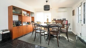 Un coin repas comprenant un buffet en bois, une table et des chaises.
