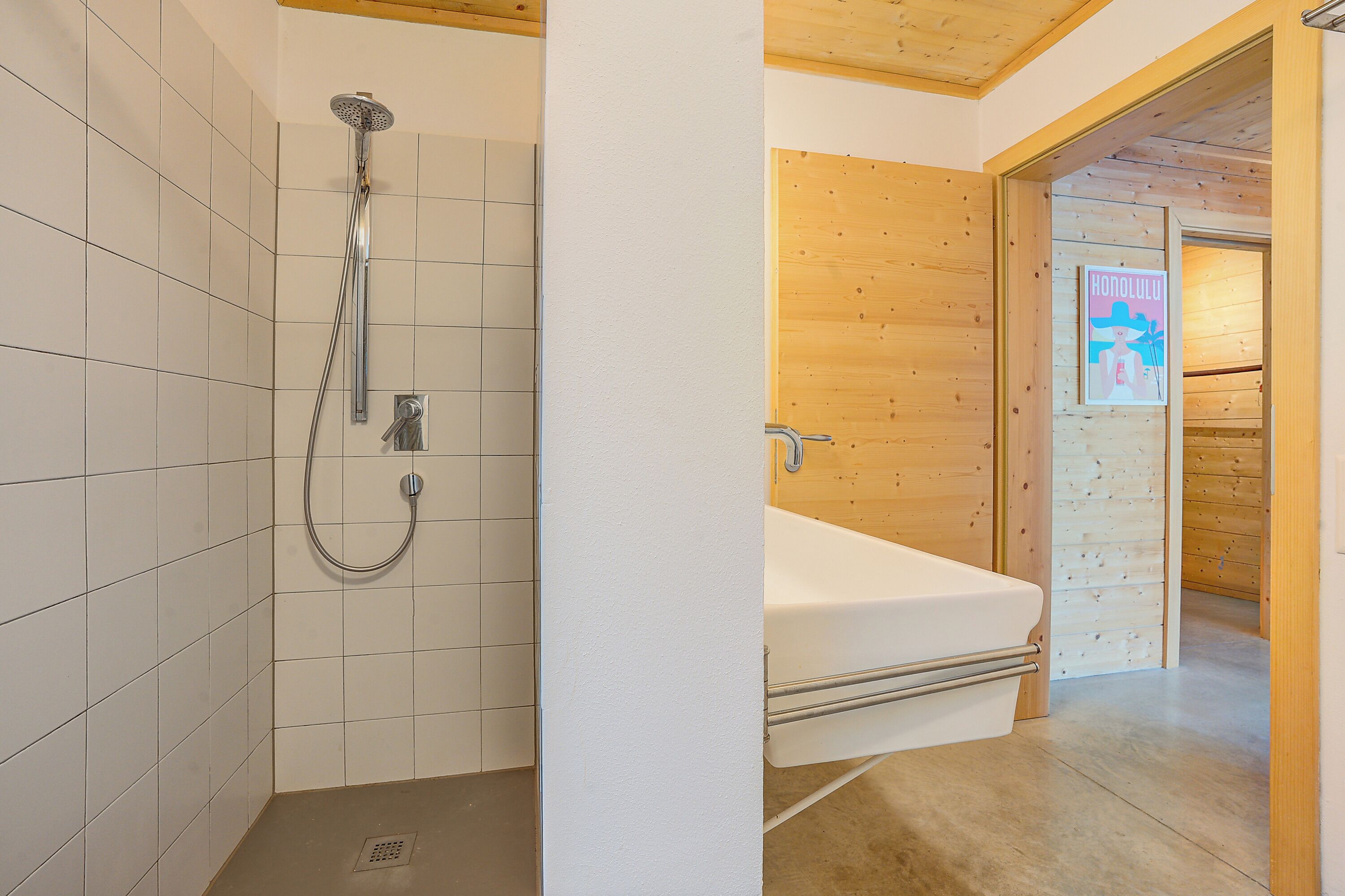 Une salle de bain avec une douche, une baignoire et un mur en bois.
