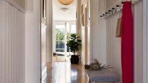 A hallway with a potted plant, a bench, and a red towel hanging on a rack. - Albert Cottage Daylesford (Daylesford)