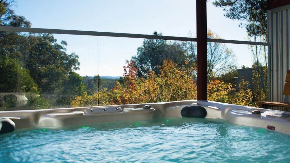 Un jacuzzi con vista a árboles y un cielo despejado.