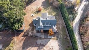 Ein Haus mit geneigtem Dach, Solaranlagen und einem umzäunten Garten.