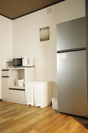 Eine kleine Küche mit Mikrowelle, Wasserkocher und Kühlschrank.