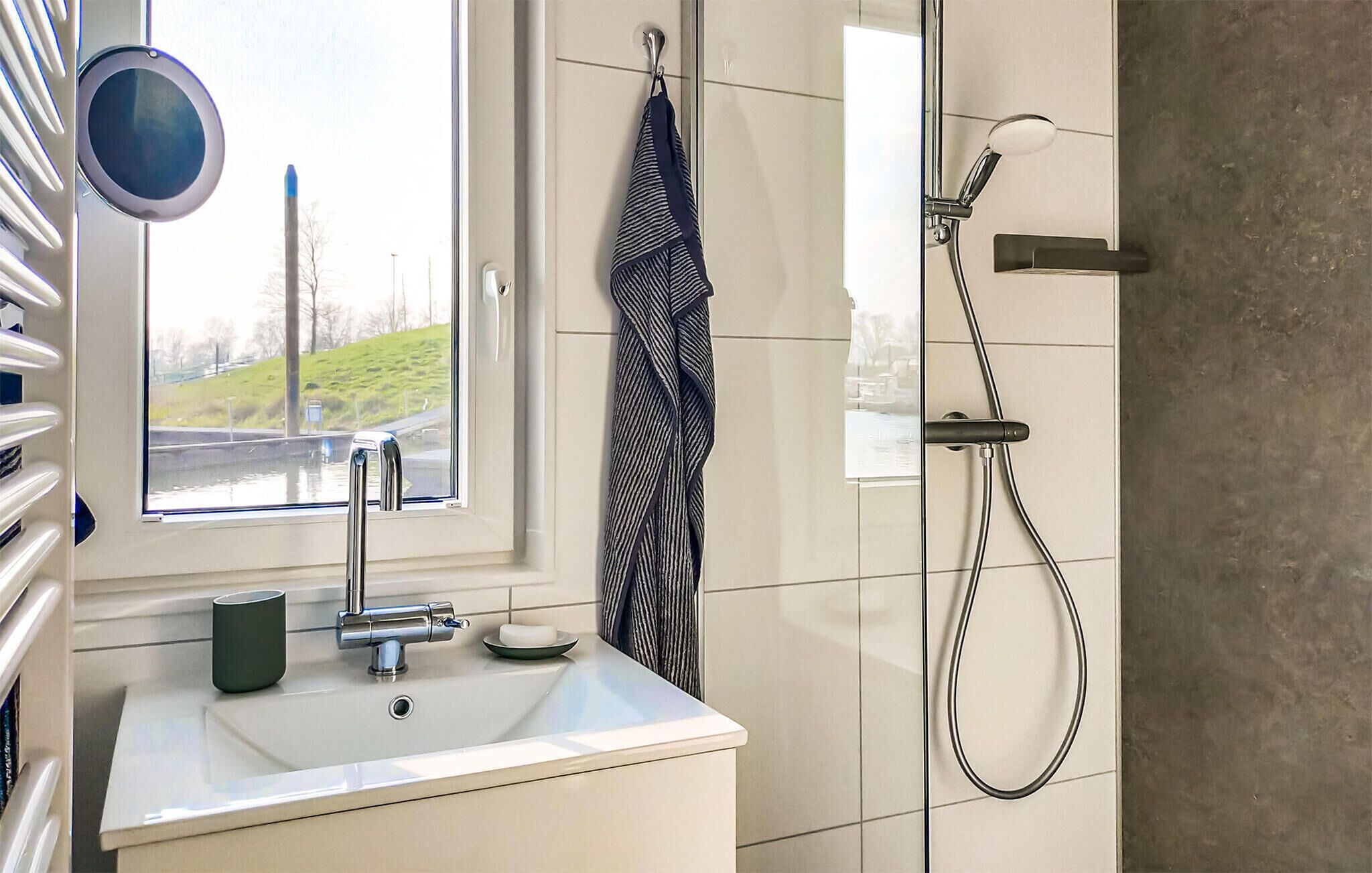 Baño con ventana, lavamanos, toallero y ducha.