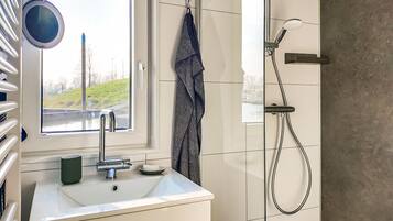Baño con ventana, lavamanos, toallero y ducha.