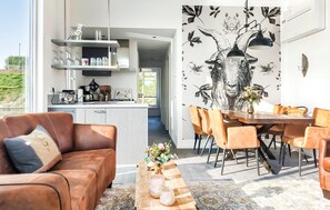 A modern living space with a dining area, kitchen, and a large window providing a view of the outdoors. - Pet friendly ship in Ohé en Laak with house sea view (Ohé en Laak)