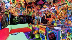 Une pièce au décor éclectique et coloré, comprenant un canapé et diverses installations artistiques.