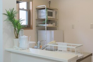 A kitchenette with a microwave, a kettle, a sink, and a plant. - Best Friend (Fukuoka City Hakataku  Katakasu)