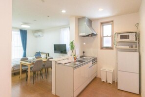 A compact kitchen with a dining area, a microwave, and a refrigerator. - Best Friend (Fukuoka City Hakataku  Katakasu)
