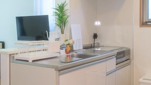 A modern kitchen with a flat-screen TV, a sink, and a dishwasher. - Best Friend (Fukuoka City Hakataku Katakasu)
